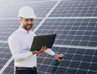 young architect standing by solar panels making diagnostics computer